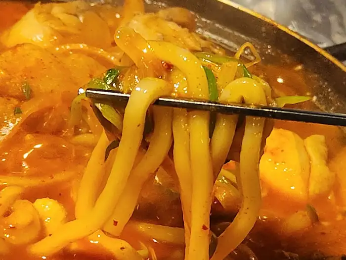 매콤한 닭볶음탕 국물에 섞인 굵은 면발과 채소