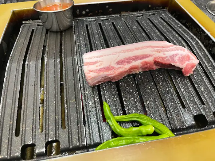 불판에 올라간 두툼한 흑돼지 초벌구이