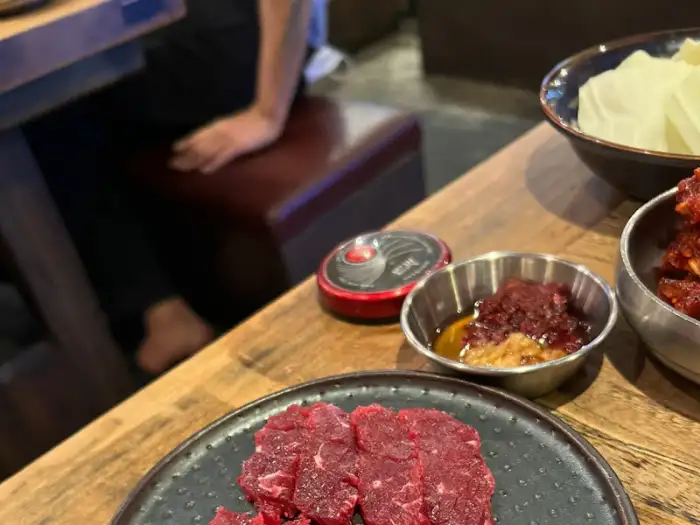 테이블 위 불판과 함께 세팅된 고기와 반찬들