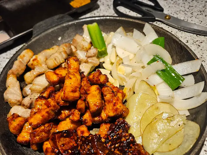 다 익은 삼겹살과 곁들임 채소, 소스가 함께 담긴 불판