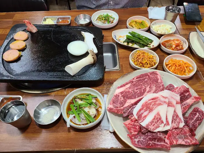 테이블에 준비된 다양한 밑반찬과 고기, 찌개 모습