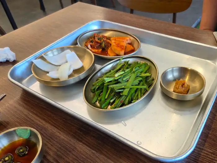 테이블 위에 차려진 돼지국밥과 밑반찬