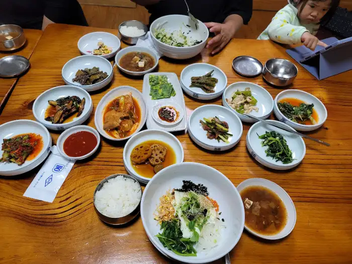 테이블 가득 차려진 반찬과 비빔밥