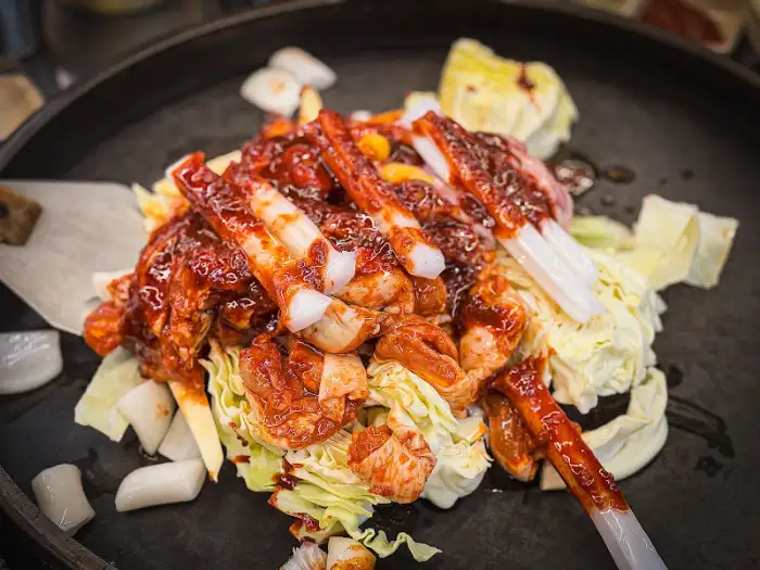 철판에 볶고 있는 닭갈비의 클로즈업 샷
