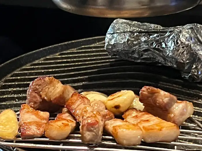 숯불 위에서 노릇하게 구워지고 있는 고기