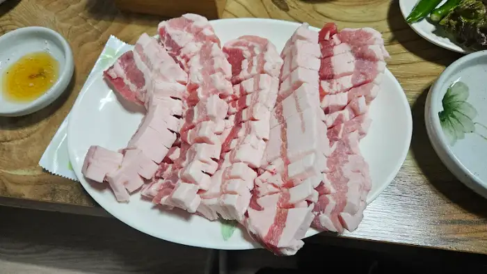 한 접시에 담긴 신선한 삼겹살 조각들