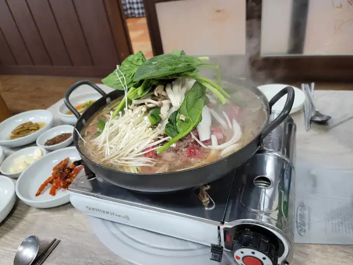 뜨거운 국물 요리가 담긴 냄비와 곁들임 반찬들