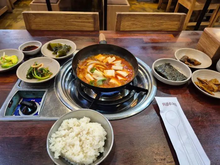 김치찌개와 여러 가지 밑반찬이 차려진 식탁 모습