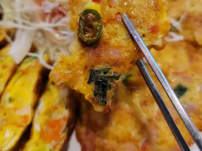 젓가락으로 참치전 조각을 집어 올린 모습