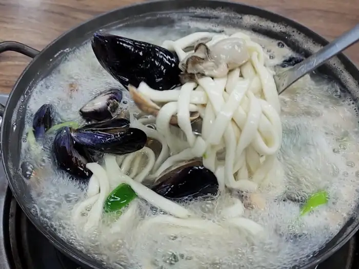 칼국수 면과 해물을 함께 건져 올린 모습