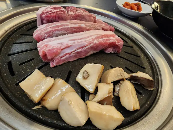 생삼겹살과 통목살이 불판 위에 올려져 익기 시작하는 모습