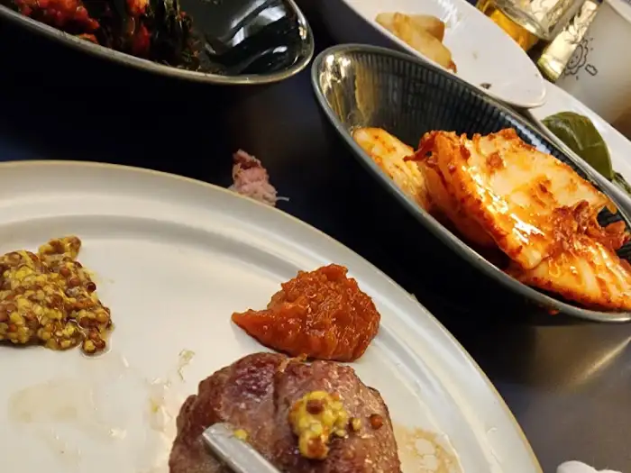 먹음직스럽게 구워진 삼겹살 조각에 소스를 얹어 놓은 모습