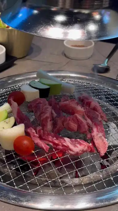 잘 익은 갈비살을 쌈 채소에 싸서 먹는 모습