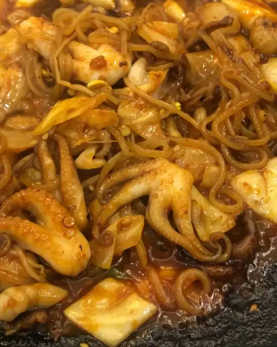 철판 위에서 익어가는 쭈꾸미와 양념, 떡, 야채 등