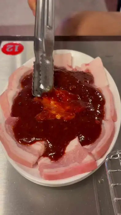 양념장을 붓고 있는 돼지고기
