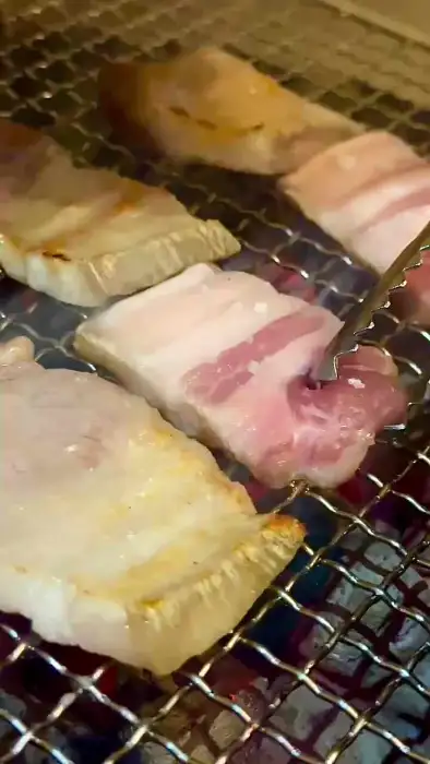 집게로 돼지고기를 뒤집고 있는 모습
