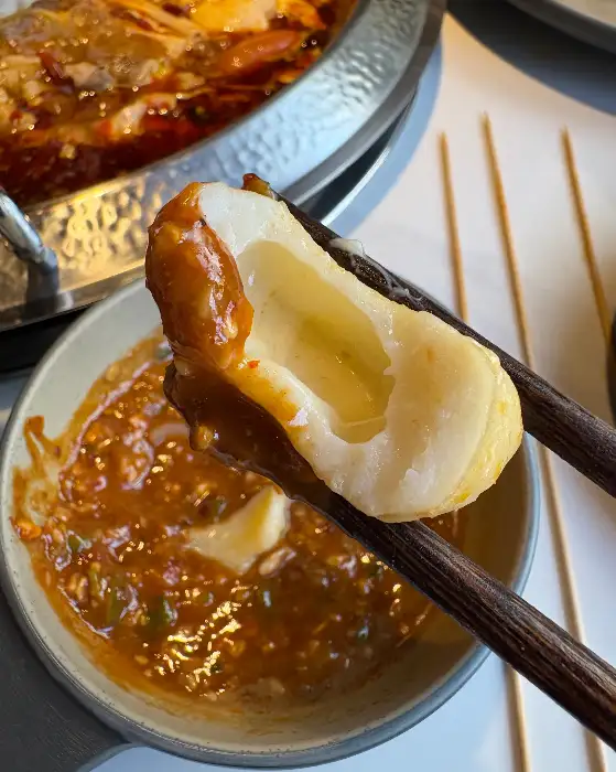 치즈 어묵 꼬치가 훠궈 국물에 찍혀 있는 모습