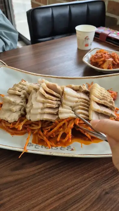 수육찜 한 점을 집는 모습