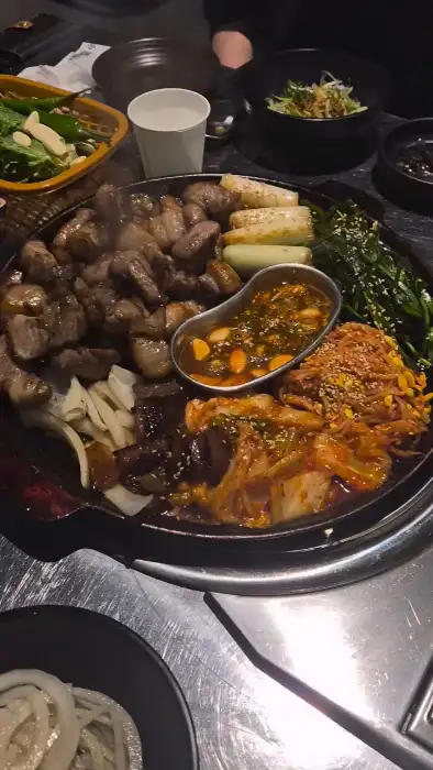 김치, 콩나물, 대파 등이 불판 위에서 맛있게 구워지고 있는 모습