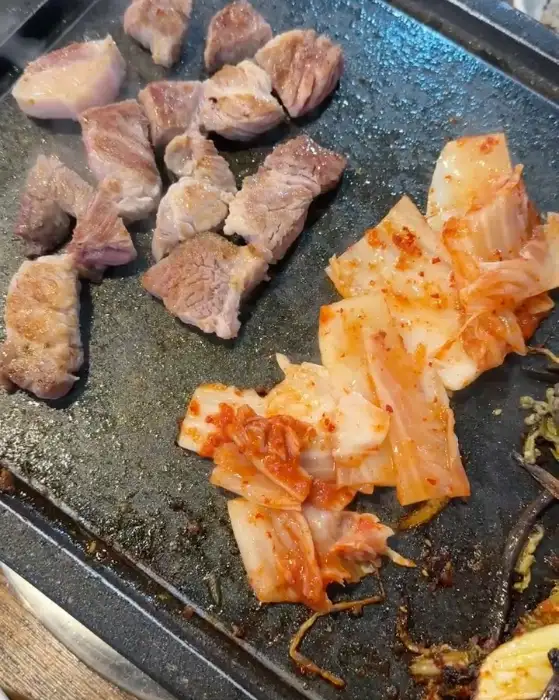 잘 구워진 흑돼지 조각과 볶아진 김치