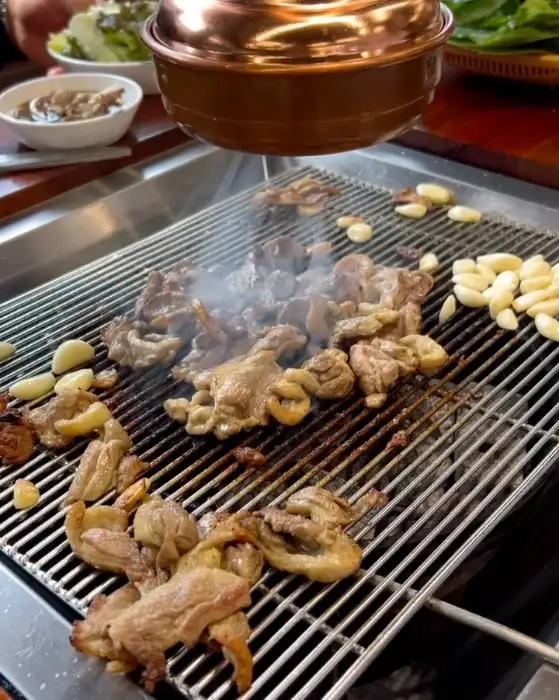 숯불에 맛있게 구워지고 있는 오리고기와 마늘