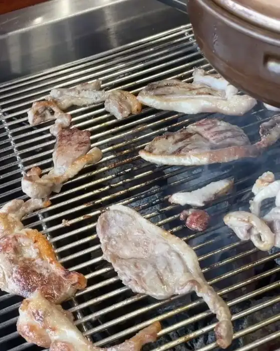 잘 익은 오리고기가 숯불 위에서 먹음직스럽게 구워지고 있는 모습
