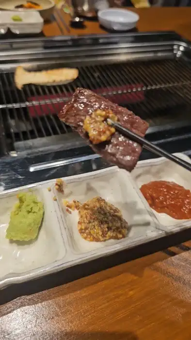 와사비와 함께 맛있는 고기 한 점을 집는 모습