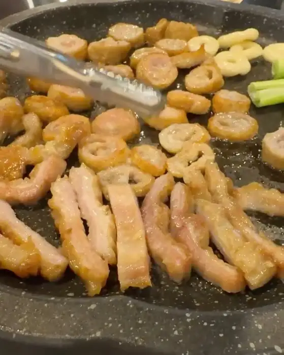 막창을 집게로 집어 뒤집는 모습
