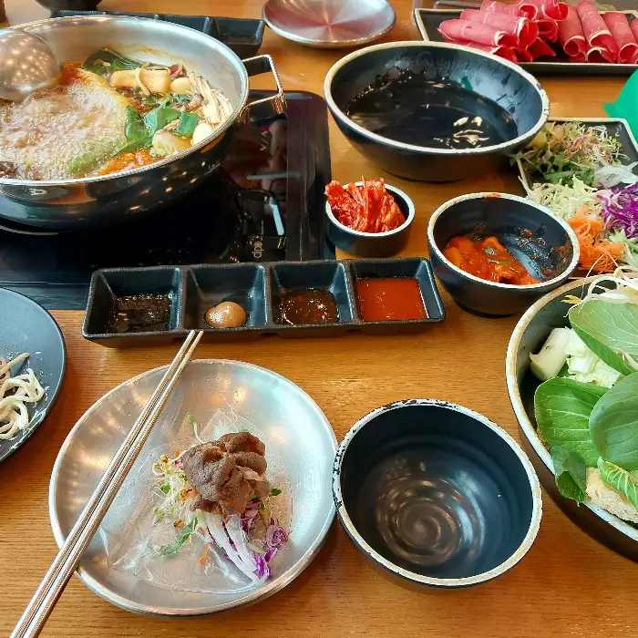 테이블에 차려진 샤브샤브 재료와 소스