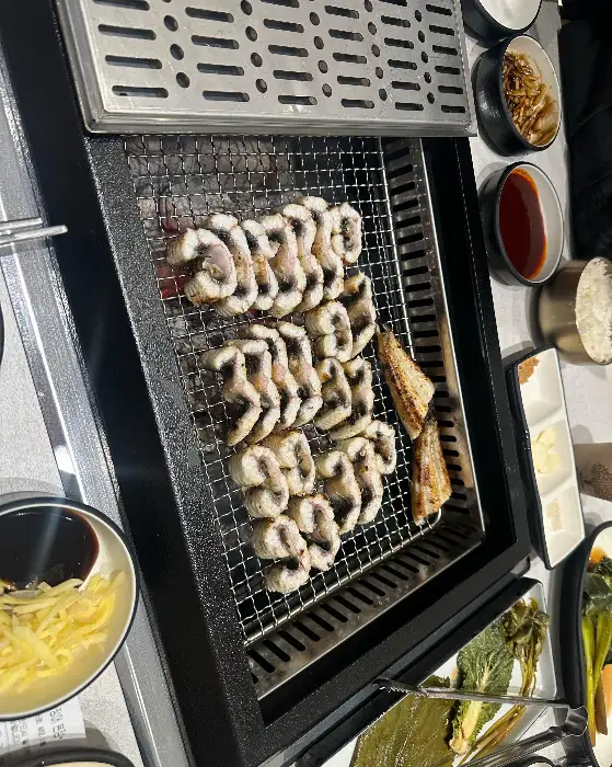 숯불 위에서 잘 익은 장어구이와 곁들임 반찬