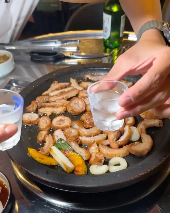 막창을 소주잔에 따르는 모습