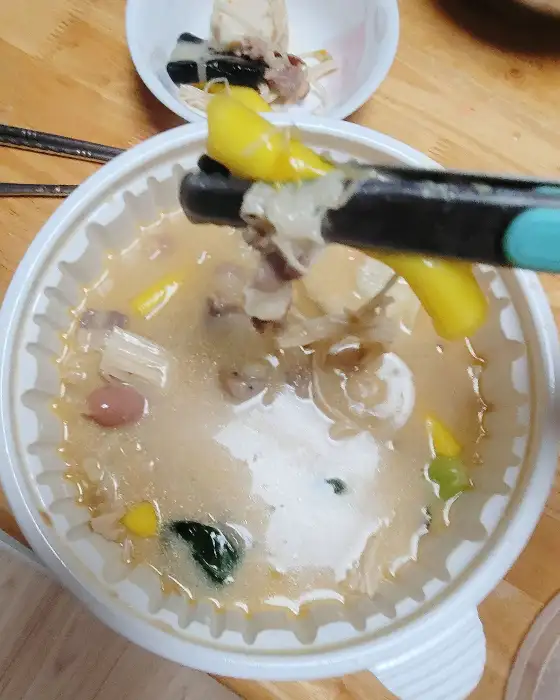 젓가락으로 마라탕 재료를 집어 올리는 모습