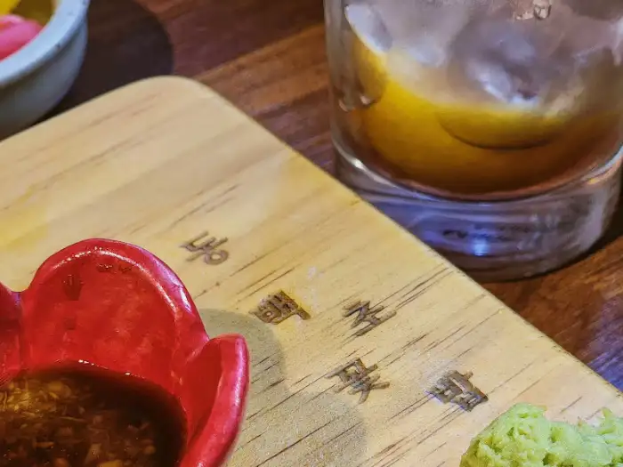 스시와 함께 나온 간장 종지와 빨간 꽃 모양의 와사비 그릇