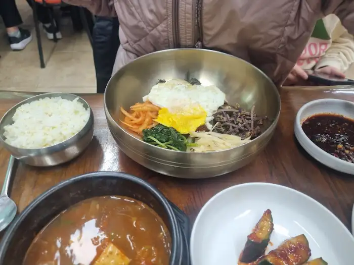 윤기 나는 밥 위에 계란 프라이와 신선한 나물들이 보기 좋게 담긴 산채비빔밥