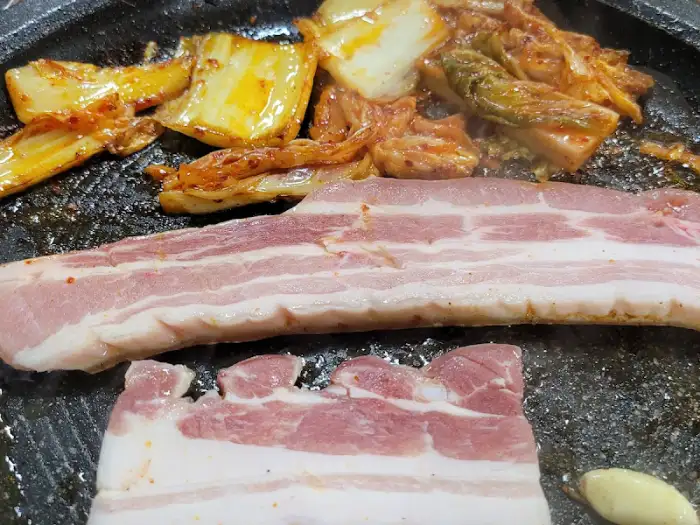 불판 위의 삼겹살과 김치