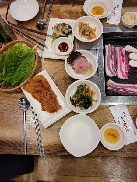 구워지는 삼겹살과 밑반찬