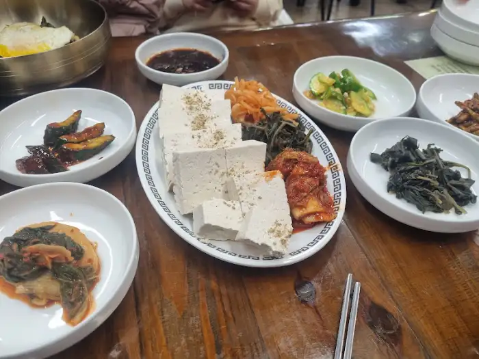 모듬 나물과 두부가 함께 차려진 반찬 구성