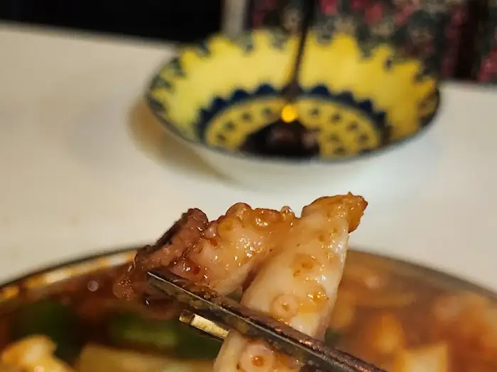 집게로 집어 올린 낙곱새 조각