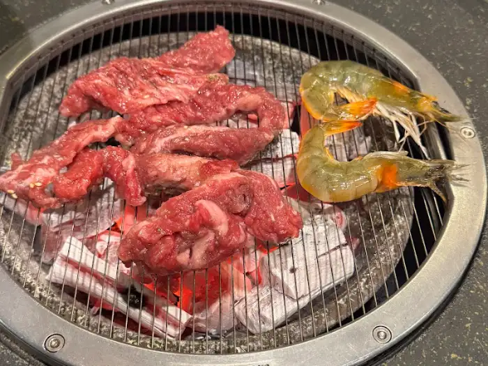 숯불 위에서 익고 있는 양념 소갈비살과 새우