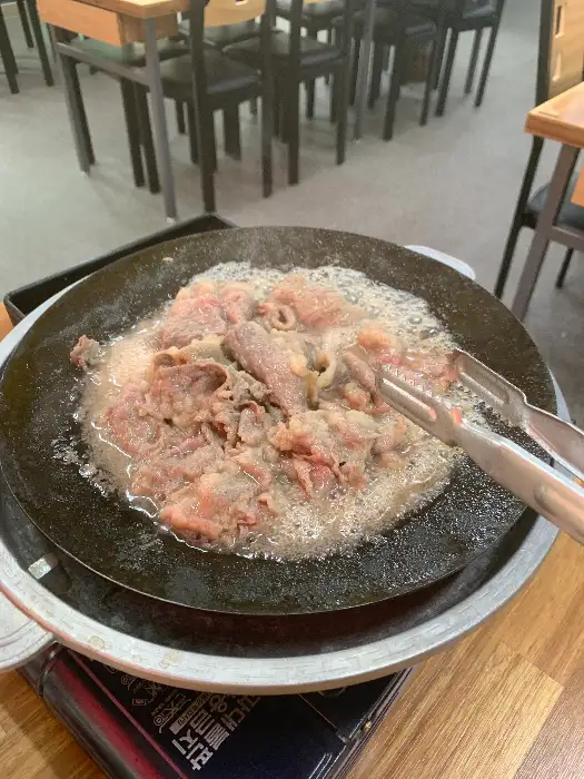 테이블에서 우삼겹을 직접 구워 먹는 모습입니다.