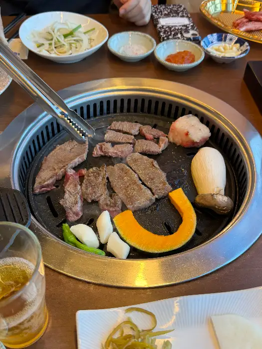 그릴 위에서 구워지고 있는 고기와 곁들임 음식들