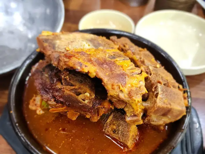 뼈해장국에 커다란 뼈 세 덩이가 담겨 있고, 그 위에 살코기가 푸짐하게 붙어 있다.