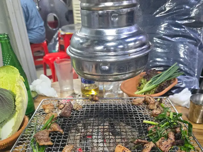 잘 익은 절창구이를 접시에 담고 있는 모습. 숯불 위의 불꽃이 보입니다.