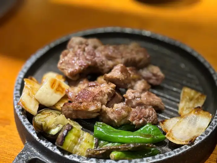 접시에 담겨 나온 잘 구워진 양갈비와 곁들임 채소