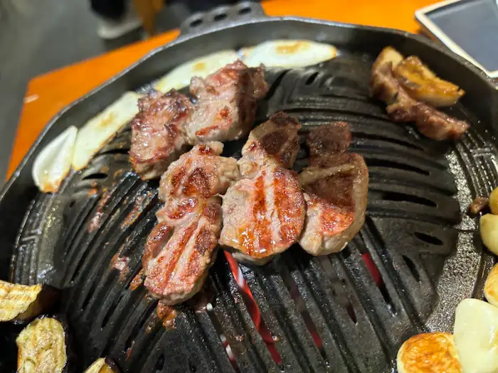 양갈비와 채소가 맛있게 익어가고 있는 불판 클로즈업