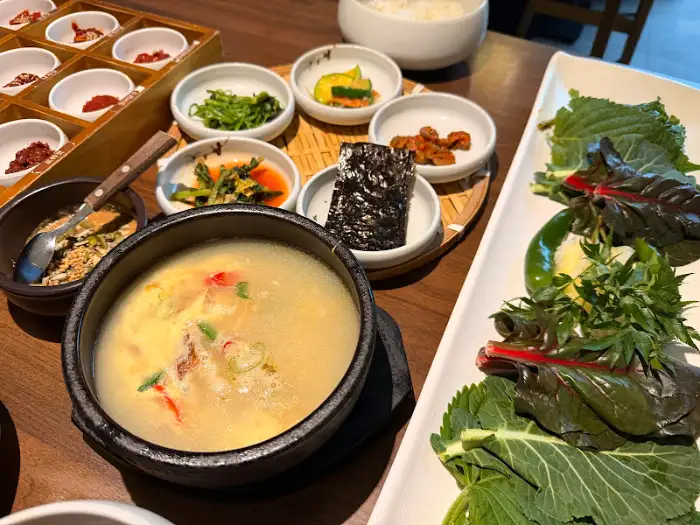 김이 모락모락 나는 황태국과 젓갈, 쌈 채소가 함께 놓여 있다.