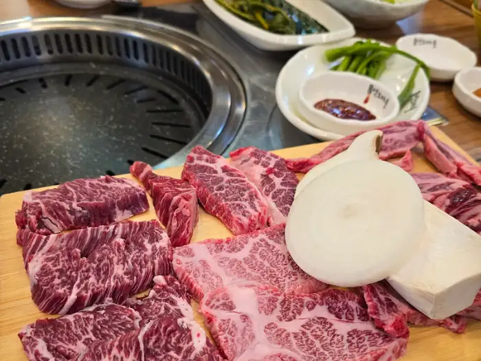 참숯 위에 신선한 약소 고기와 야채가 준비된 모습