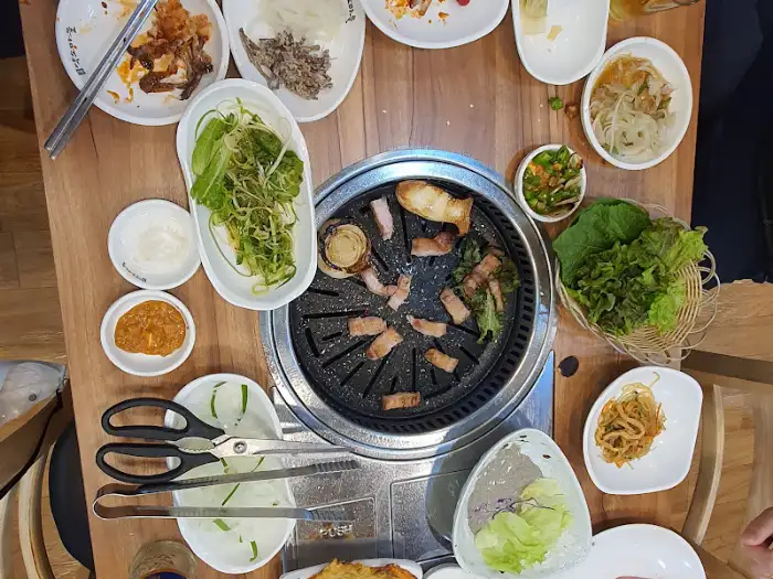 테이블에 차려진 다양한 밑반찬과 고기
