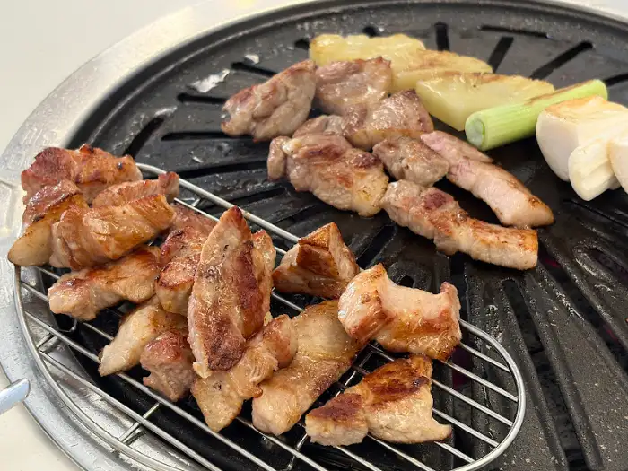 팬 위에서 맛있게 구워지고 있는 삼겹살 조각들