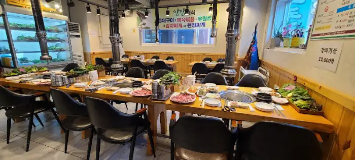 테이블 위에 차려진 다양한 음식과 쌈 채소